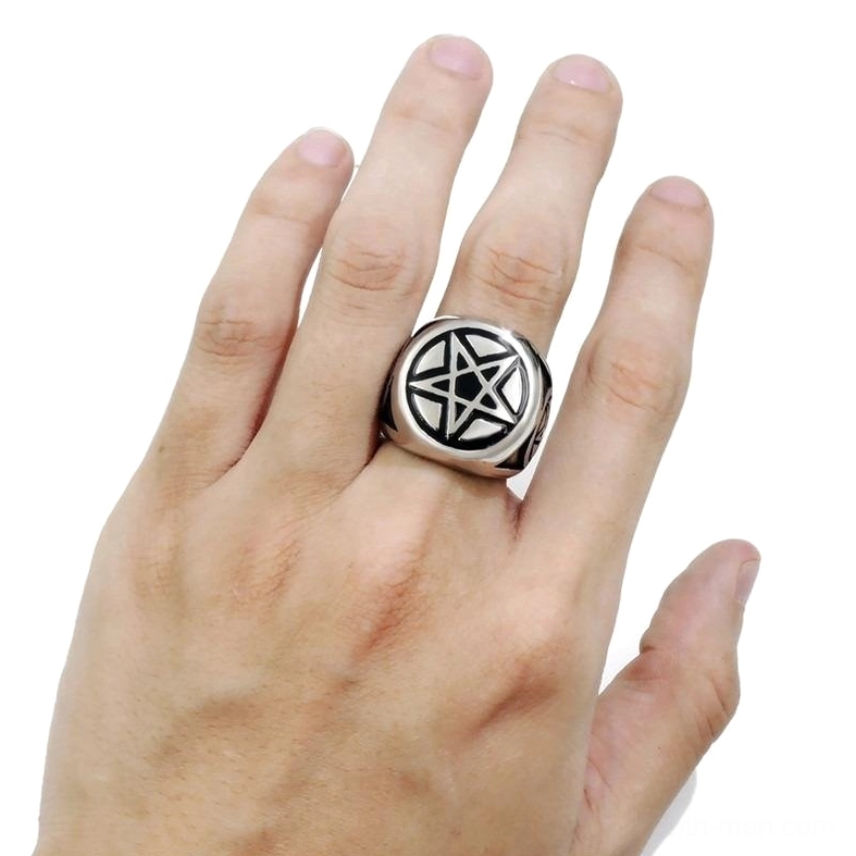 Pentagram metal ring worn on male finger close-up front view occult symbol jewelry