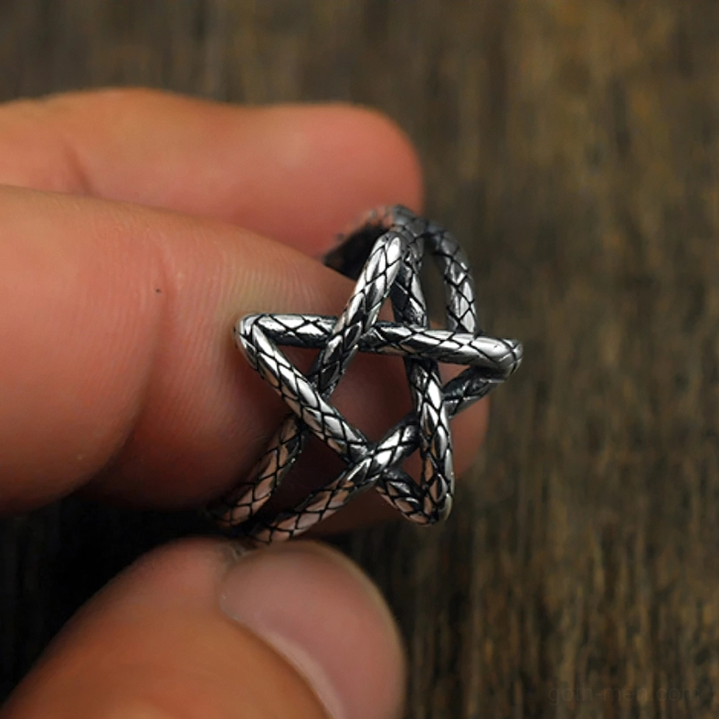Hollow pentagram ring held between fingers close-up adjustable design