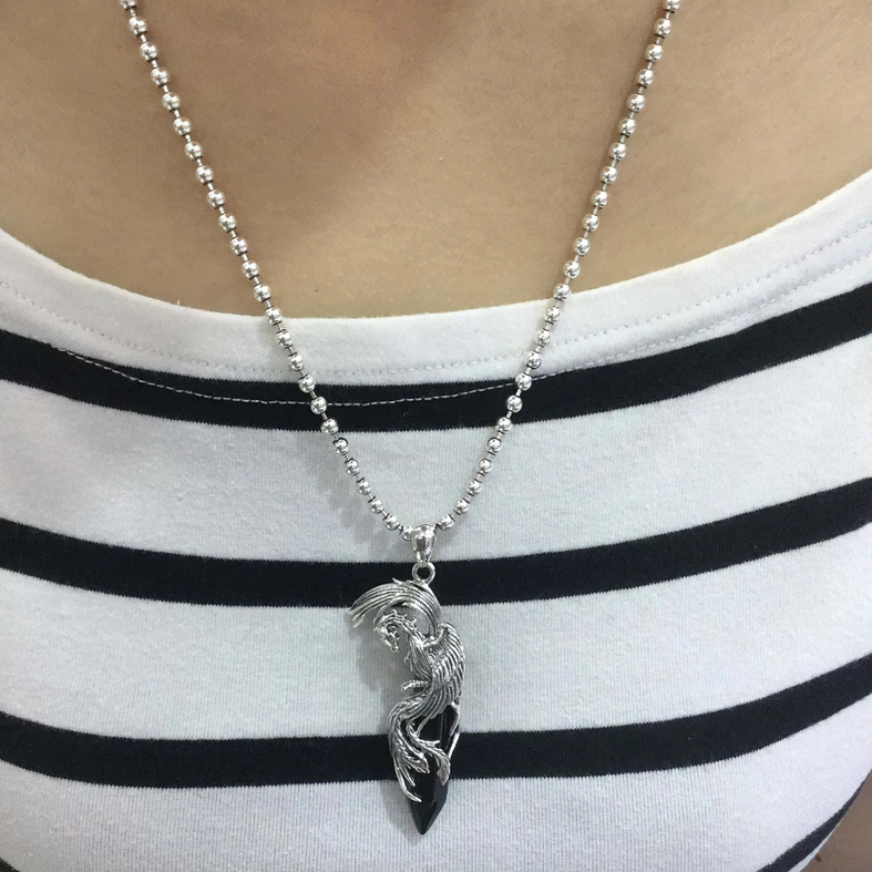 Worn on model: black obsidian phoenix pendant necklace with silver chain, styled on neck with striped crew neck top