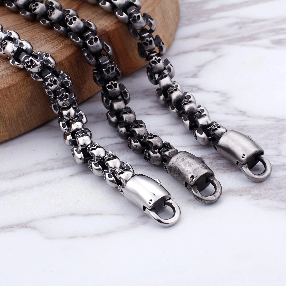 Polished silver gothic skull link bracelet catching light to showcase intricate skull articulation