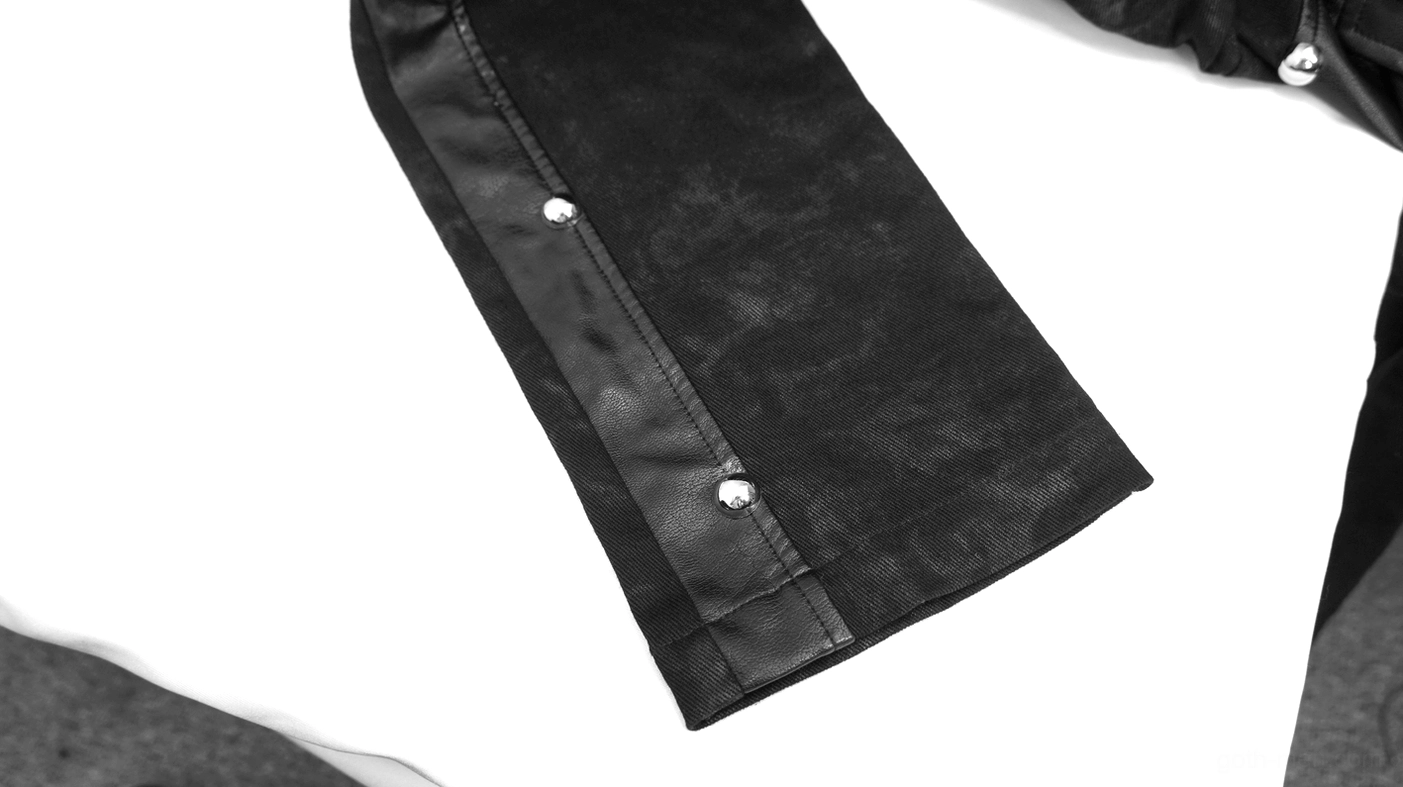 Punk leather pants hem detail close-up - metal snap buttons and faded black fabric with leather trim