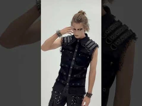 Black studded gothic vest shoulder hardware detail - metal D-rings and grommets close-up