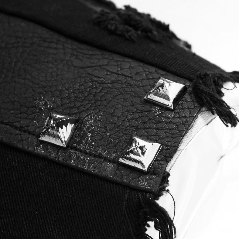 Close-up of square pyramid metal studs and frayed distressed leather fabric on gothic waistcoat