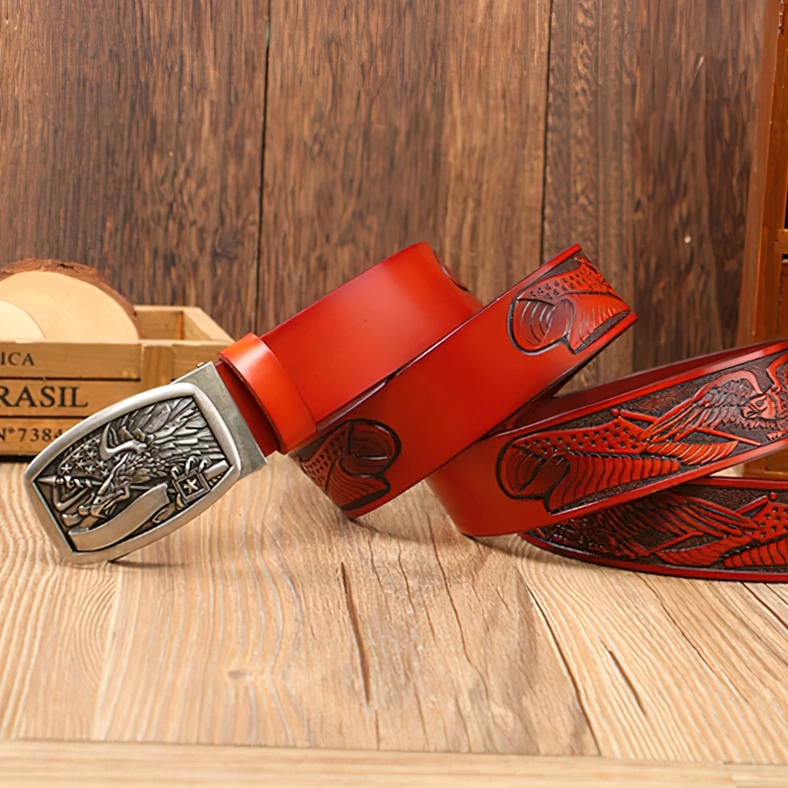 Bright red embossed gothic eagle leather belt with silver buckle on wooden surface