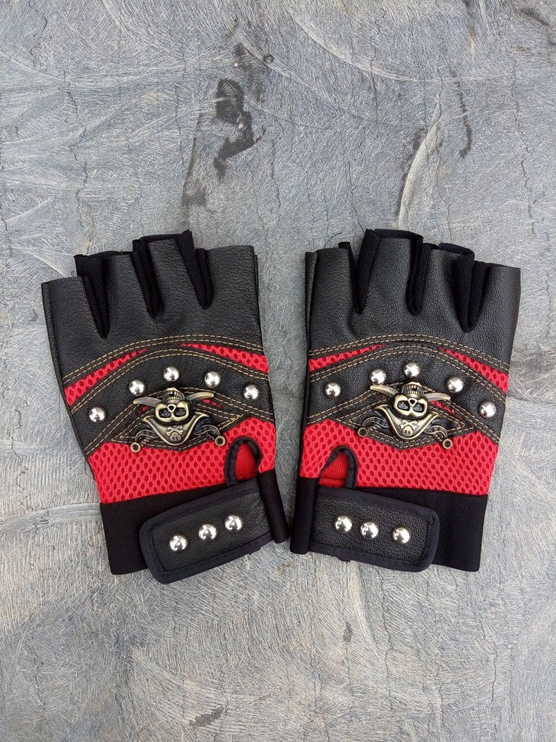 Red mesh punk fingerless gloves with silver metal skull decoration and red mesh accents on stone texture angled view