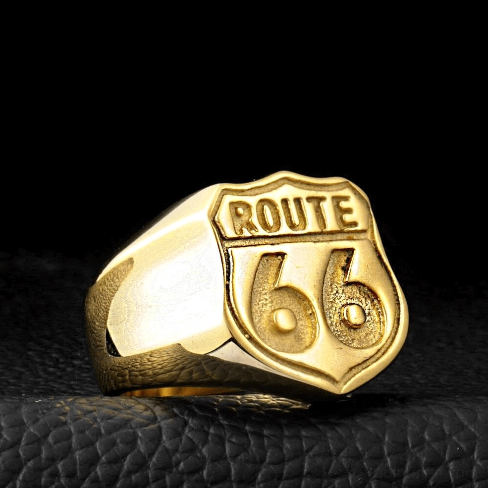 Gold-polished Route 66 shield ring worn on hand against leather background, showing fit and finish
