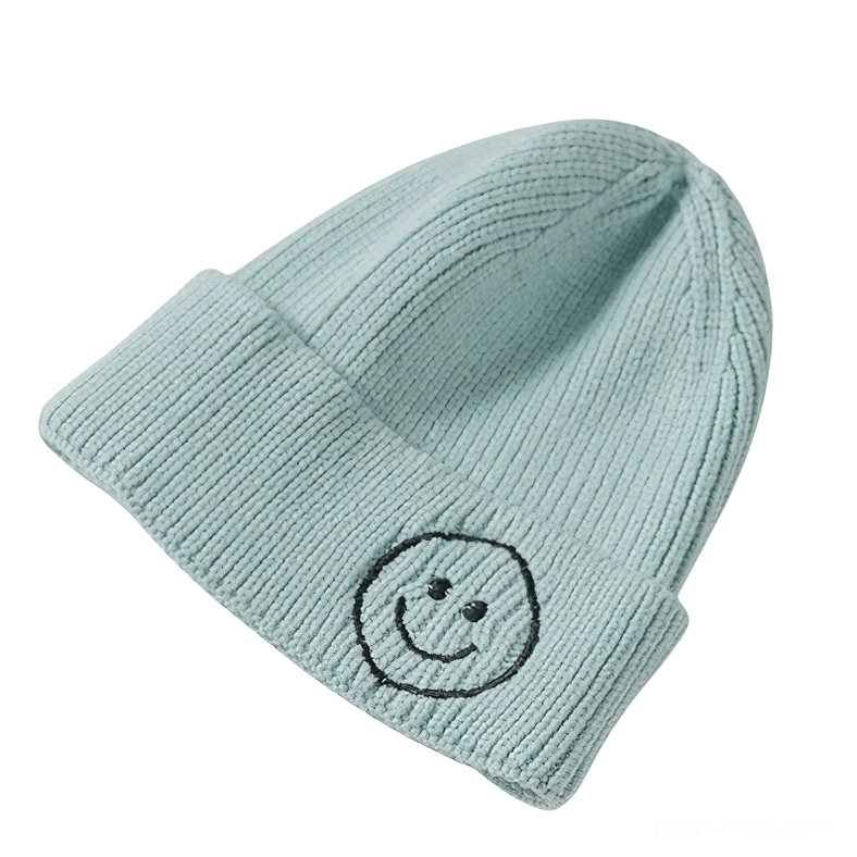Light sage blue ribbed knit beanie with black smiley embroidery, soft gothic style