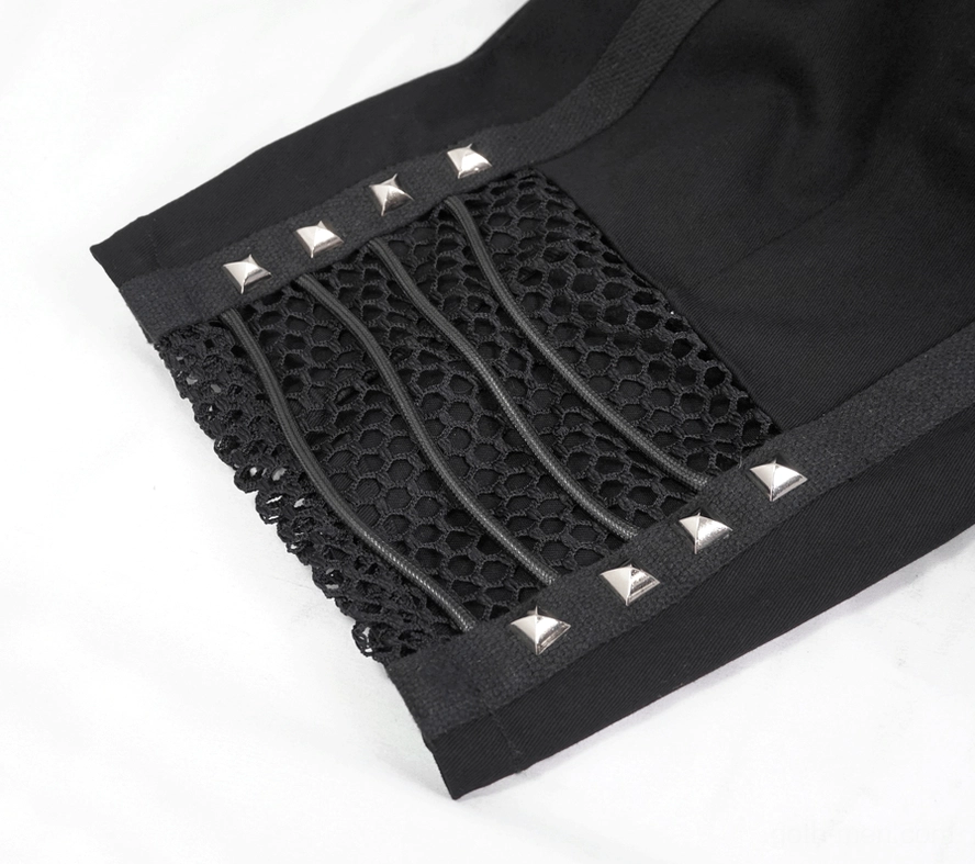 Close-up detail of black gothic shorts hem with pyramid rivets and fishnet fabric