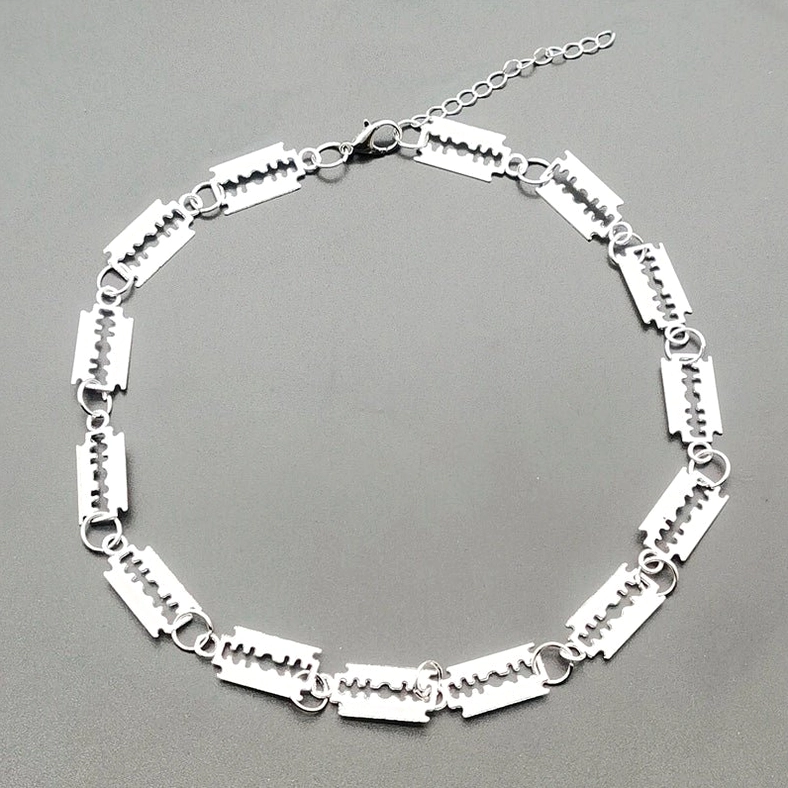 Overhead flat lay shot of silver blade choker necklace displaying full length chain with lobster clasp closure and adjustable extension link