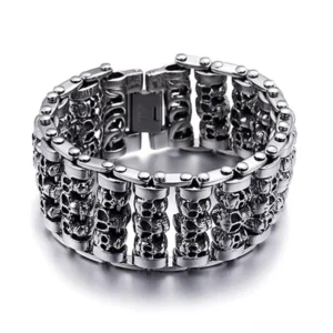 Silver gothic skull chain bracelet for men with stacked skull heads and fold clasp, flat lay top view