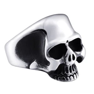 Silver stainless steel skull ring with bright polished finish, detailed skull facial features visible from three-quarter angle on white background