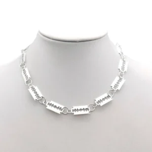 Silver razor blade gothic choker necklace worn on mannequin head, front view showing 14 interlocking blade links with chain design