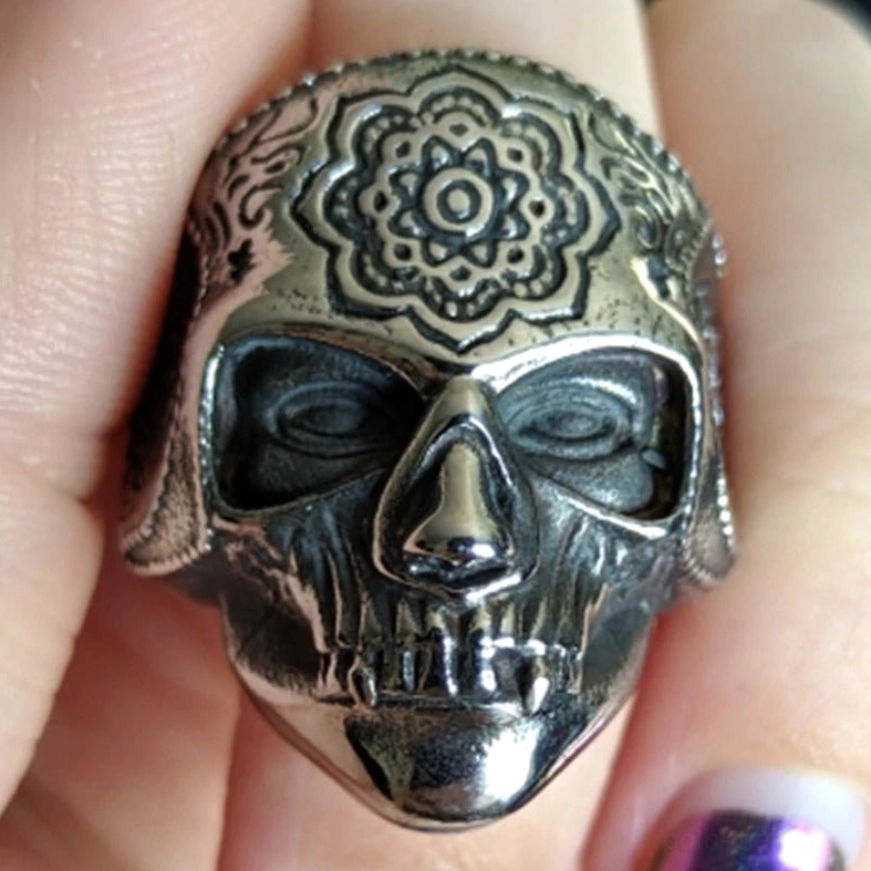 Mandala sugar skull ring worn on hand showing aged silver metal finish and detailed skull facial texture in natural light
