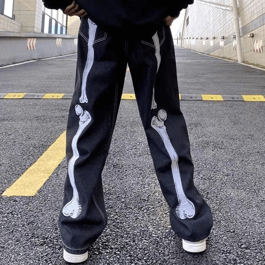 Wide leg skeleton bone gothic jeans rear side view on male model, outdoor urban street scene