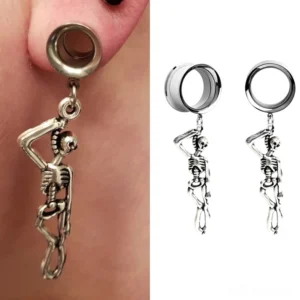 Single antique bronze skeleton ear tunnel with dangling skeleton pendant worn on earlobe, close-up side view