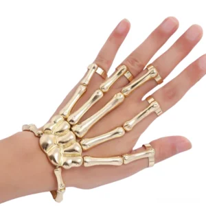 Gold tone skeleton hand slave bracelet front facing view on female hand against white background, showing polished metal finish and matching finger rings