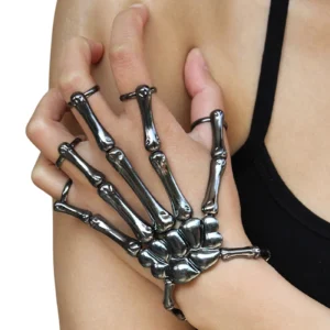 Gunmetal skeleton hand slave bracelet worn on female model's hand, close-up side view showing integrated skeletal finger rings with dark metallic finish