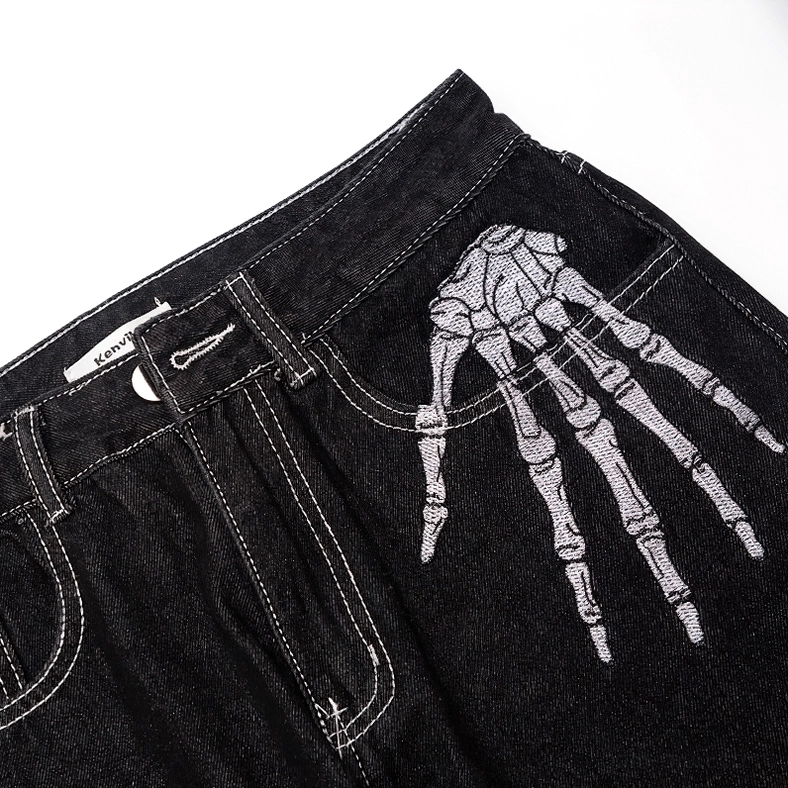 Skeleton hand embroidery bone print gothic jeans front close-up, black denim distressed wash