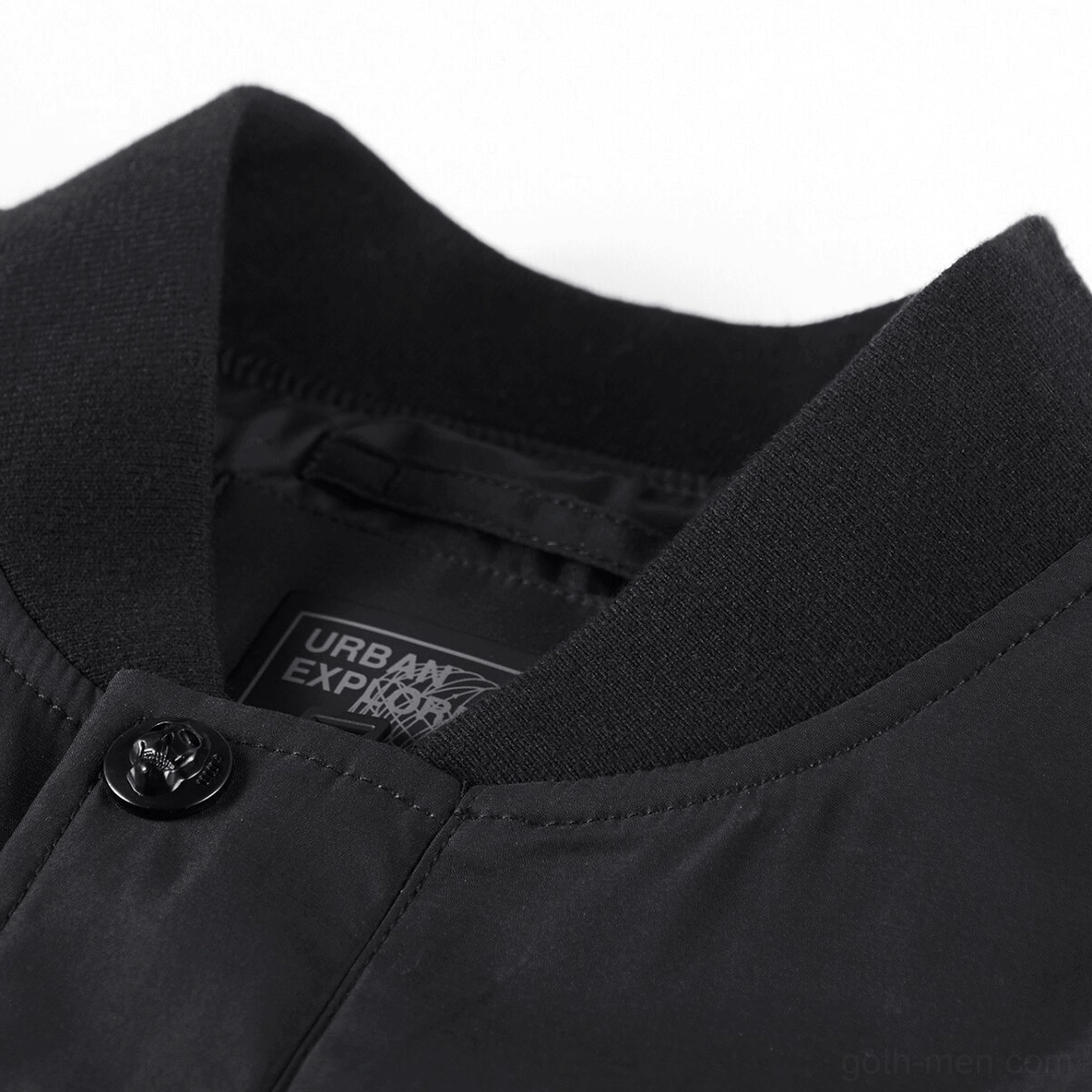 Gothic bomber jacket stand collar close-up detail - ribbed neckline with metal snap button and brand label