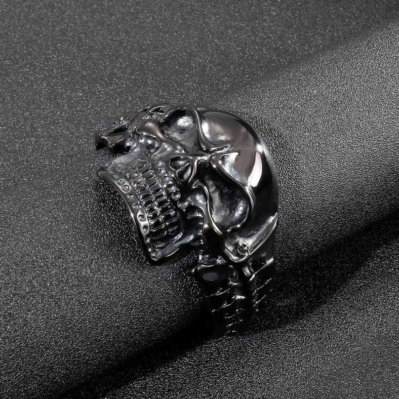 Gothic skull open cuff bracelet side view on cylindrical display showing glossy black finish