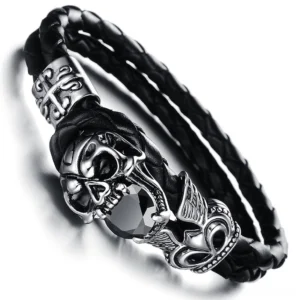 Close-up side view of winged skull charm bracelet showing detailed stainless steel craftsmanship and braided leather construction