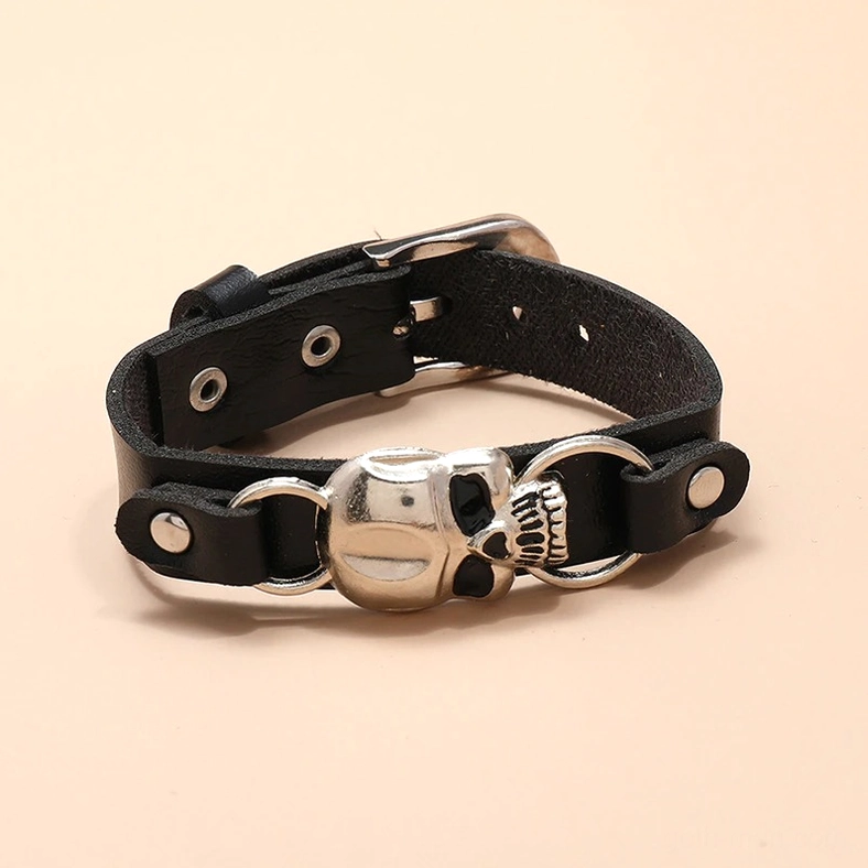 Skull leather cuff bracelet flat lay top-down view with bronze metal details and double D-rings