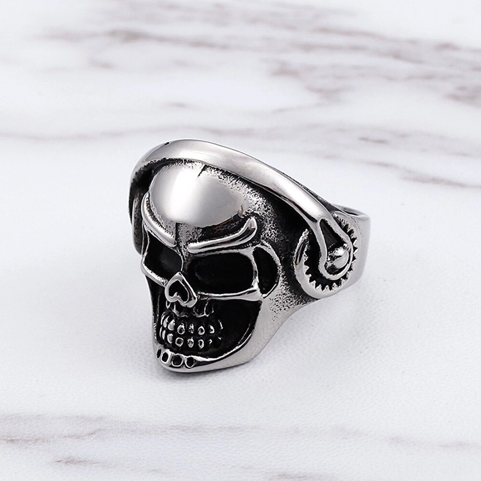 Gothic skull headphone biker ring front three-quarter view on marble, full skull display with antique silver tone