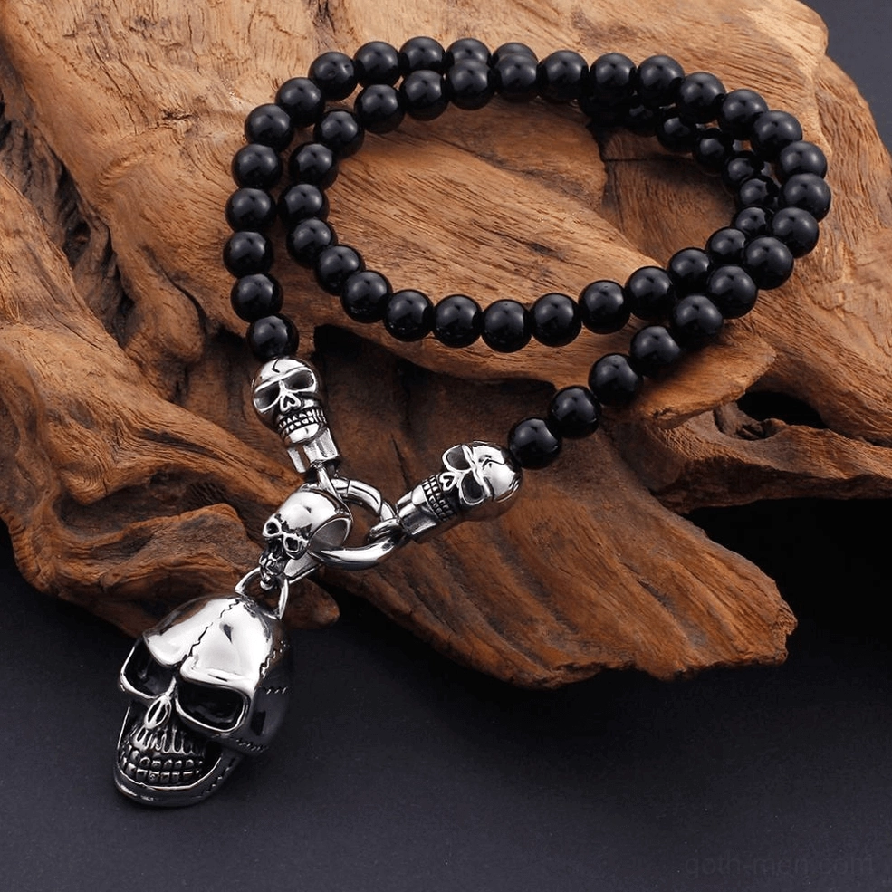 Side flat lay gothic skull beaded necklace driftwood background dark aesthetic jewelry