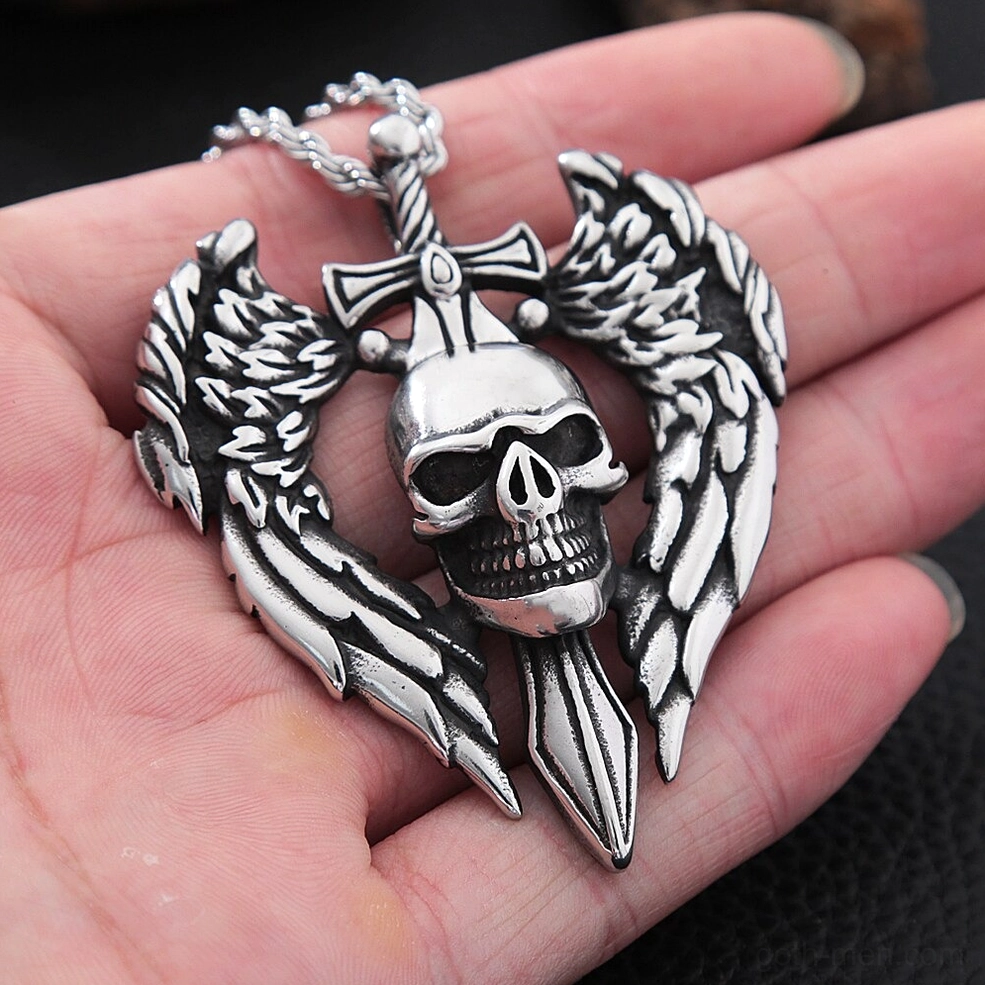 Winged skull pendant held in hand showing size scale and carved metal craftsmanship of gothic necklace jewelry