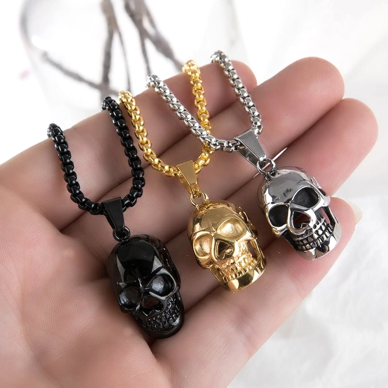 Complete stainless steel skull necklace collection three colors displayed on hand in overhead view