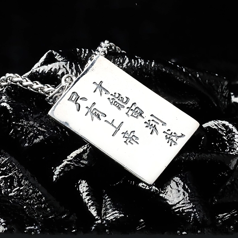 Reverse side of gothic skull pendant showing polished silver surface and engraved 'Only God can judge me' inscription with wheat chain