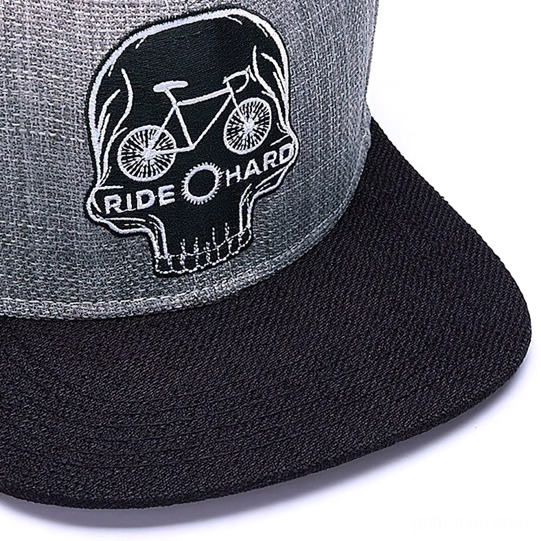 Close-up detail of embroidered skull logo with bicycle and RIDE HARD text on skull ride hard gothic snapback cap, showcasing embroidery craftsmanship
