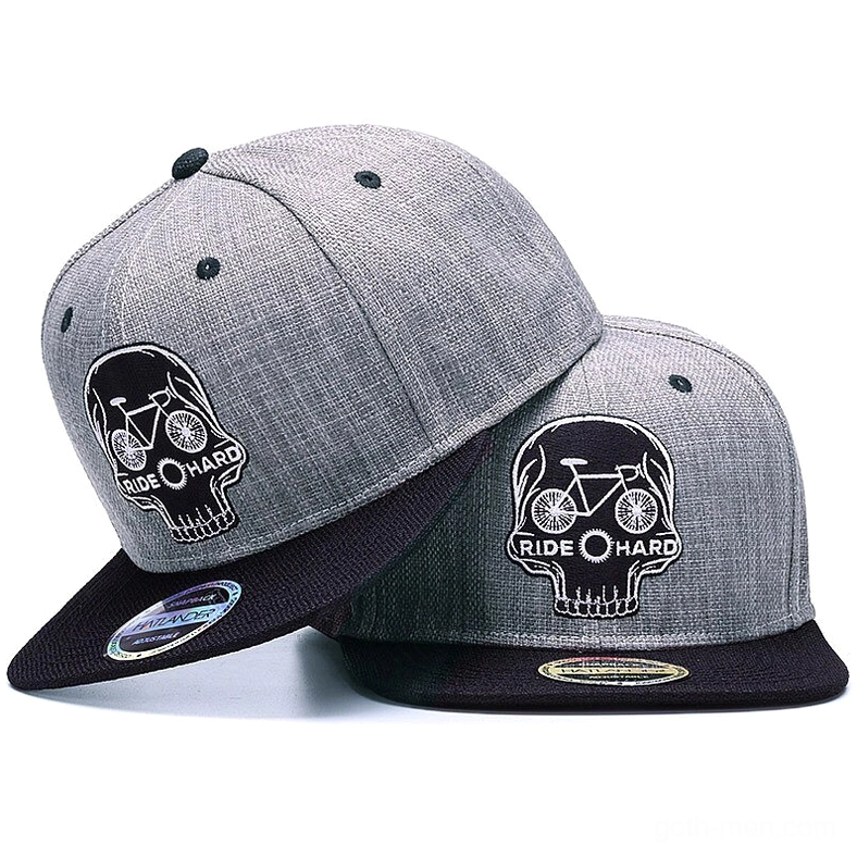 Two matching skull ride hard gothic snapback caps displayed at oblique angle, showing heather gray crown with black embroidered skull and bicycle motif