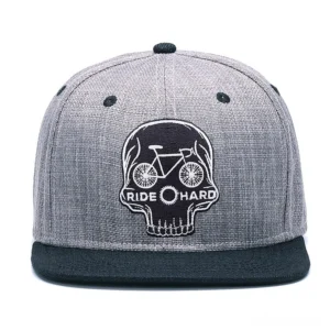 Skull ride hard gothic snapback cap front view, displaying embroidered skull with bicycle and RIDE HARD text on heather gray 6-panel baseball cap with black flat brim
