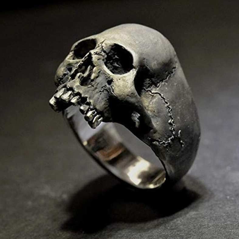Silver skull ring close-up showing realistic tooth details and sharp carving on dark background
