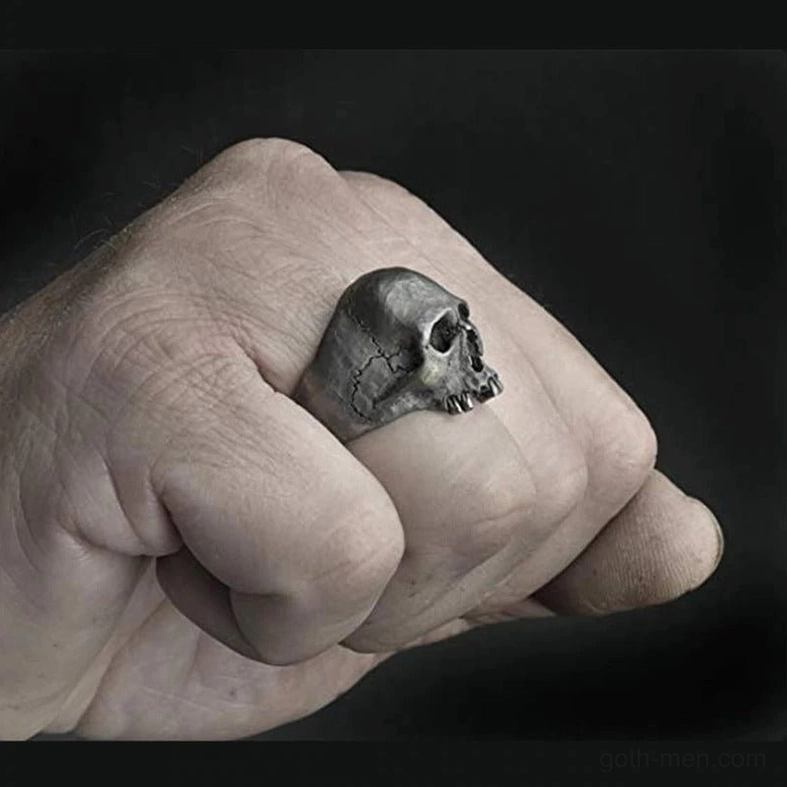 Skull ring side profile view on male hand showing aged silver finish and skull depth