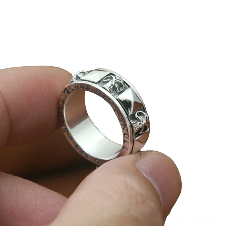 Rotating skull ring side profile worn on finger showing polished inner band and skull engravings