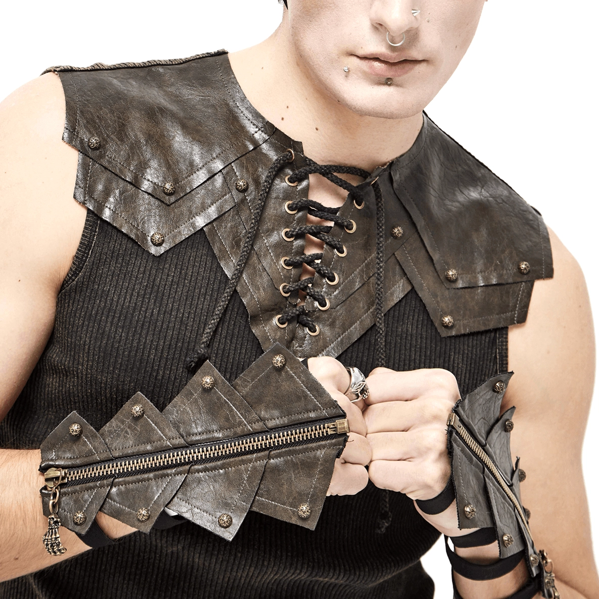 Man in gothic makeup displaying brown fingerless gloves with brass hardware and layered wrist straps, alternative fashion