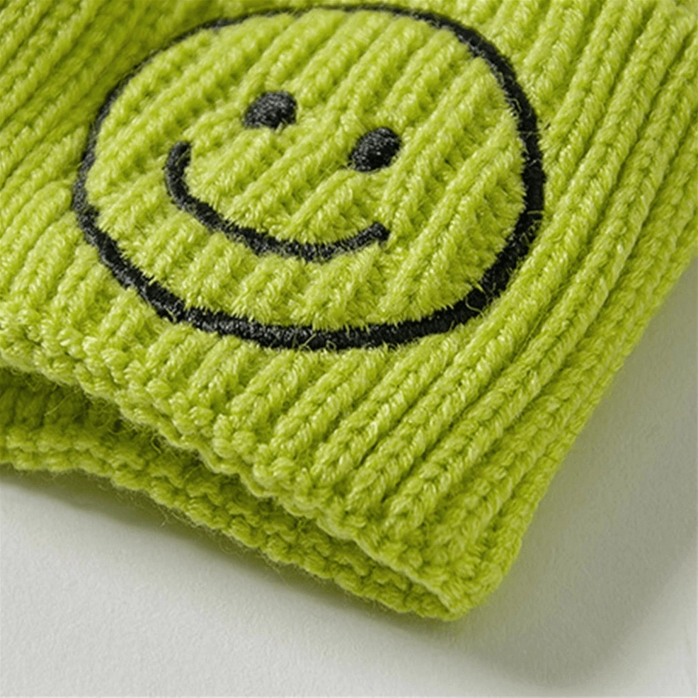 Close-up detail of ribbed knit texture and smiley embroidery on gothic beanie