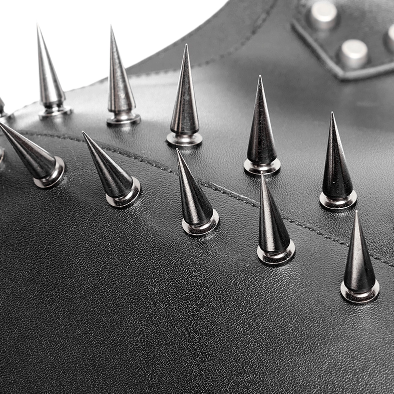 Flat lay close-up of spiked shoulder harness showing silver conical metal spike arrangement on black leather
