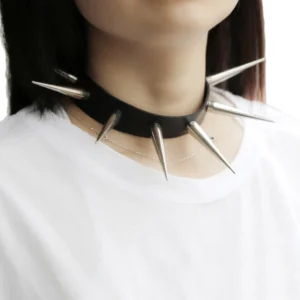 Black spiked gothic choker with silver metal spikes worn on female model neck, front close-up showing adjustable buckle detail and leather construction