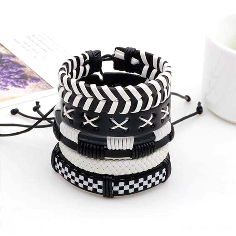 Stacked black and white gothic leather bracelet set with geometric patterns - front display with decorative props