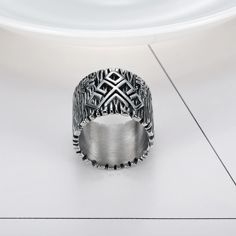 Overhead view of brushed silver stainless steel gothic ring with complete circular rim and intricate rune engravings on textured background