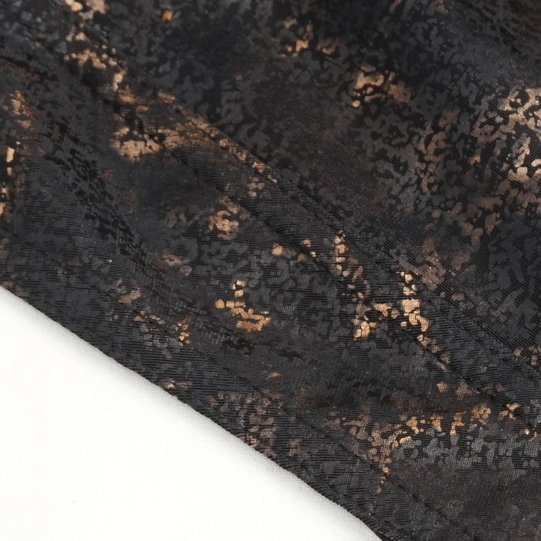 Steampunk bandana fabric close-up showing black base with scattered bronze marbled pattern and woven textile structure