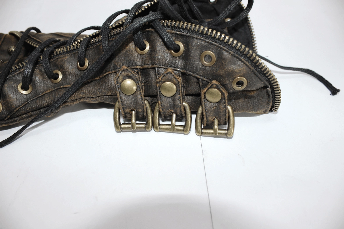 Angled close-up of brown steampunk glove showing multiple metal buckle straps and distressed leather surface