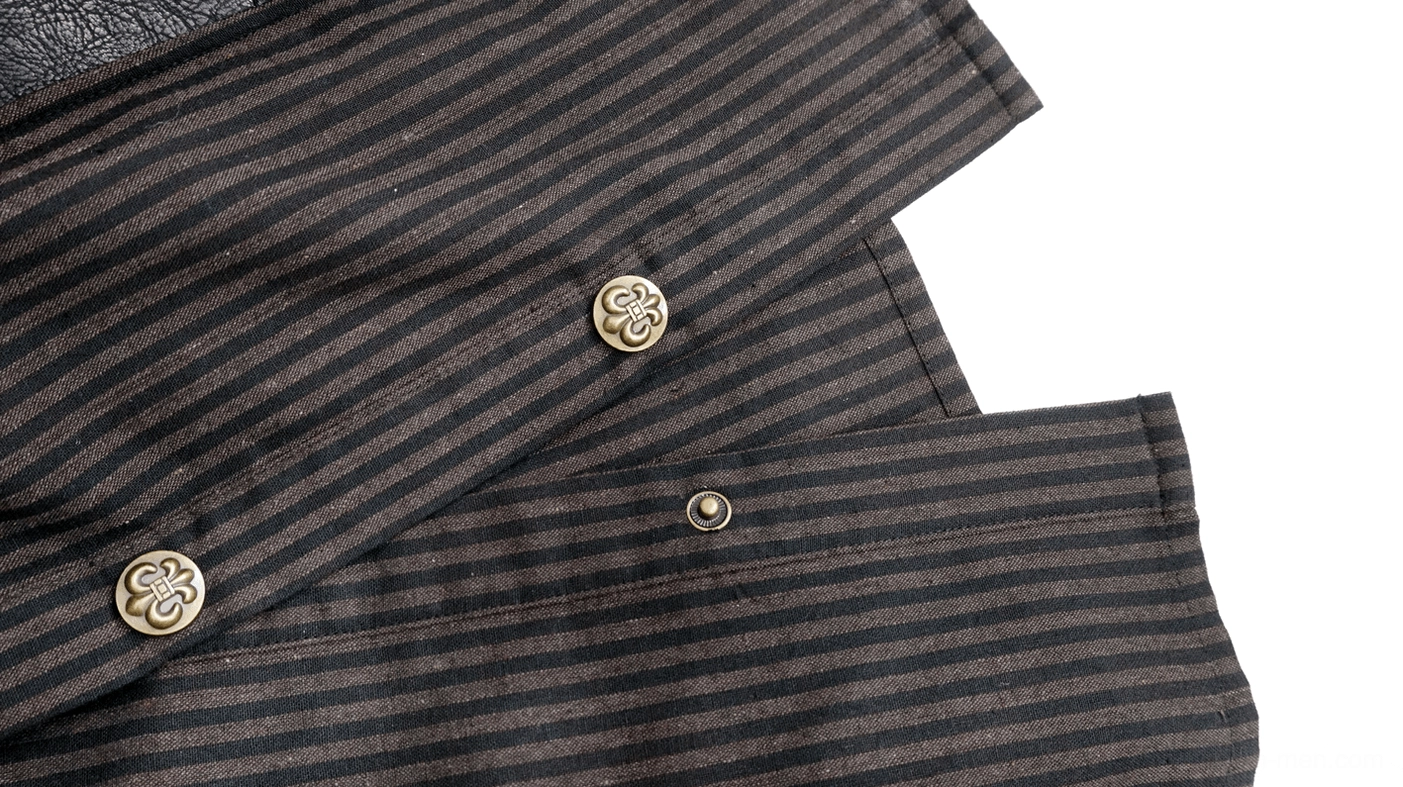 Close-up of ornate vintage bronze button placket detail on steampunk gothic shirt