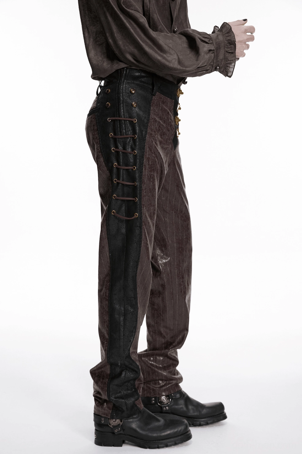 Front full-body view of model wearing brown steampunk faux leather striped pants with metal clasps and black trim