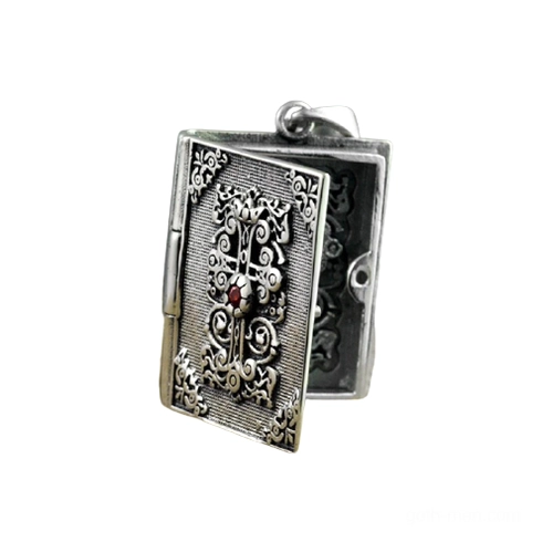 Open silver bible locket pendant showing hinged mechanism and interior carved cross detail