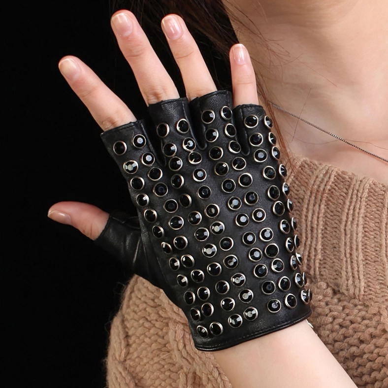 Black half-finger rivet leather gloves worn on model's left hand, side close-up view indoors, punk aesthetic