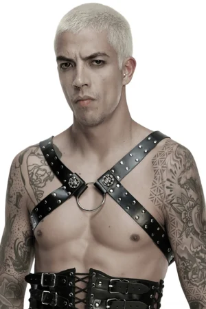 Shirtless model wearing black studded leather harness with metal O-ring and detachable chains, gothic fashion